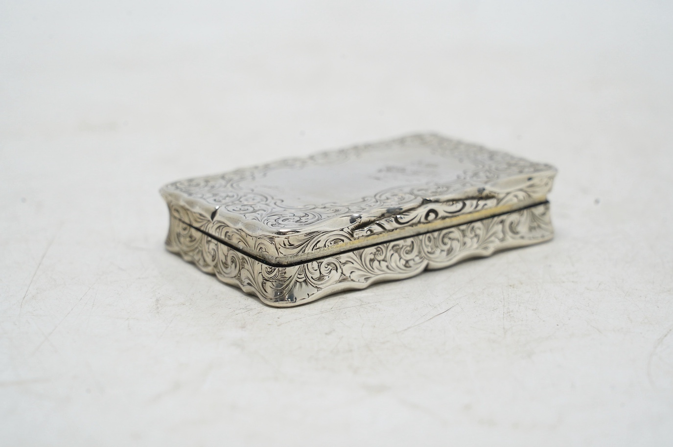A Victorian engraved silver snuff box, by Nathaniel Mills, Birmingham, 1851, 66mm. Condition - fair